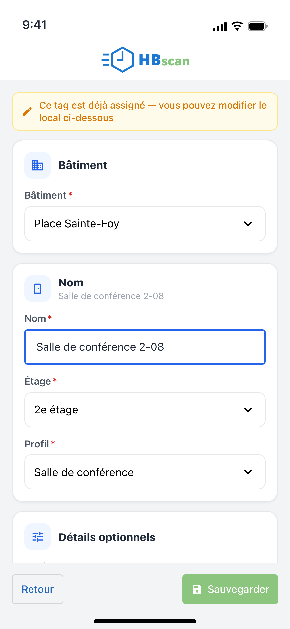 Capture: fiche d'un local ouverte en scannant sa puce; bandeau orange « Ce tag est déjà assigné — vous pouvez modifier le local ci-dessous », champs Bâtiment, Nom, Étage, Profil et bouton vert « Sauvegarder ».